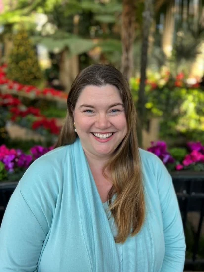 A person smiling at camera  Description automatically generated